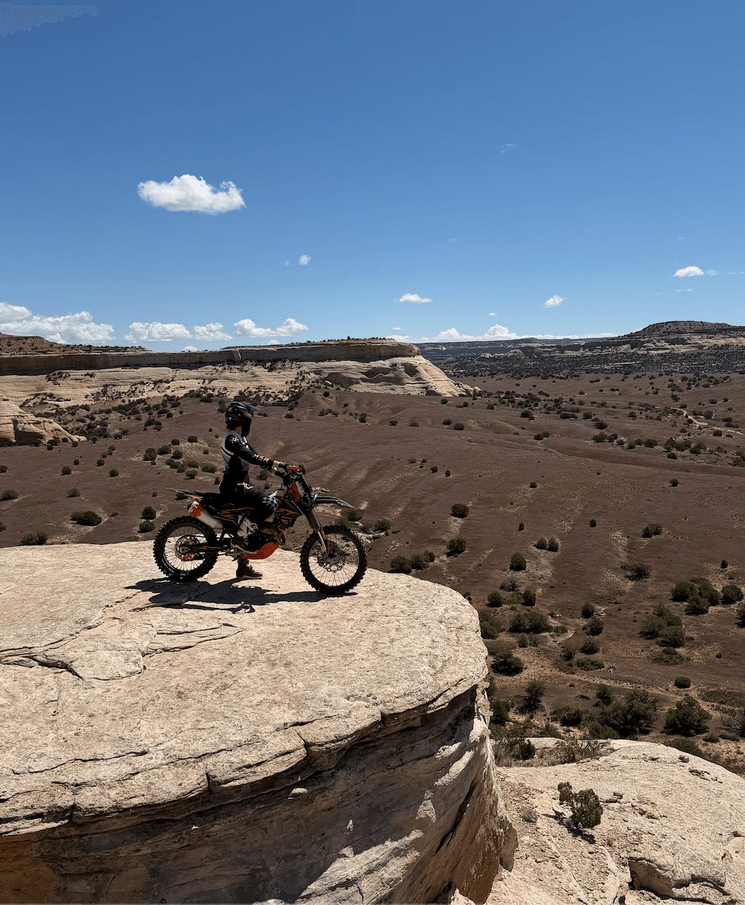 Jen-L on her KTM dirt bike on a canyon rim in the Colorado backcountry